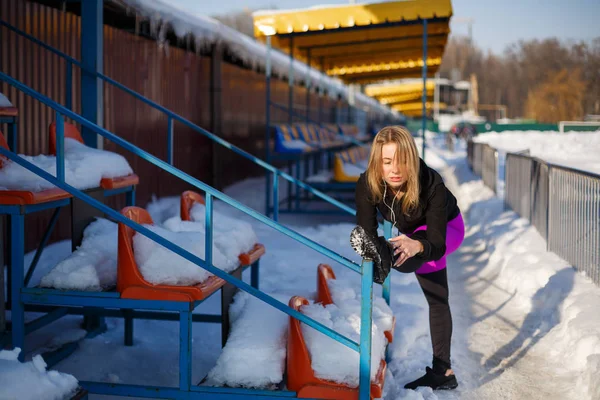 Молодая Кавказская Блондинка Фиолетовых Леггинсах Растягивающая Упражнения Трибуне Снежном Стадионе — стоковое фото