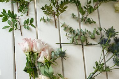 Çiçekçi kadın elleri damat yakası için çiçek toplar. Olay taze çiçek süslemesi. Çiçekçi iş akışı. Düğün ziyafeti tasarımı.