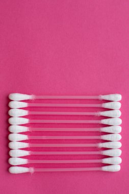 Pembe bir arka plan üzerinde dikey bir çizgi koydu pamuk tomurcukları üzerinde closeup üstten görünüm.