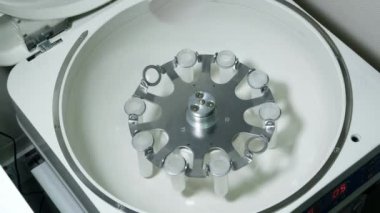Üst düzey bir kadın kimyacı bazı örnek kan tüpler içinde bir santrifüj için bazı test laboratuarında kurma closeup