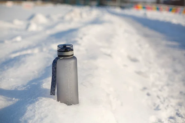 雪の中でグレーのスポーツプラスチック飲料ボトル — ストック写真