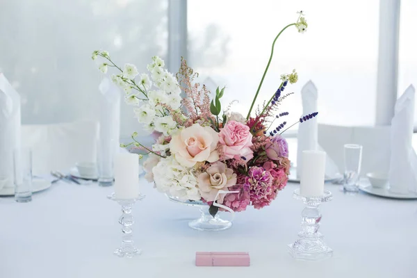 Букет свіжих квітів в центрі сервірованого столу в — стокове фото