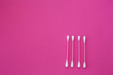 Pembe arka planda yatay çizgide beyaz başlı dört pembe pamuk tomurcuğunun üst görüntüsü