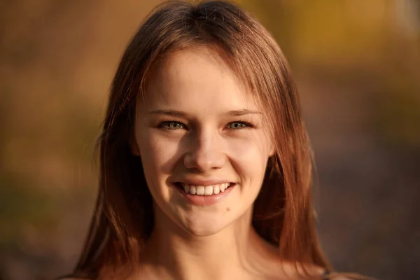 Potret wanita muda tersenyum di taman musim gugur dengan daun kuning — Stok Foto