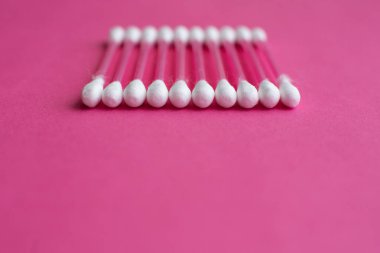 Pamuk tomurcuklarının yakın plan yan görüntüsü pembe arkaplan üzerinde yatay bir çizgide yatar
