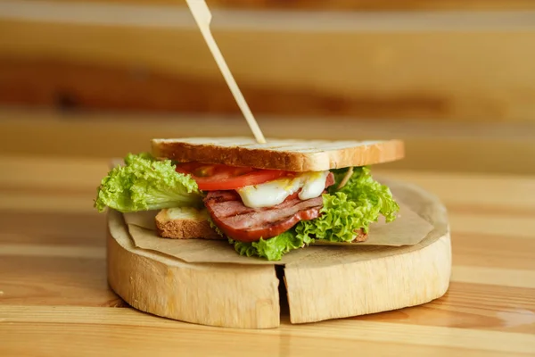 Saftige Sandwich mit gegrilltem Brot und Speck warten auf Sie auf Holzteller — Stockfoto