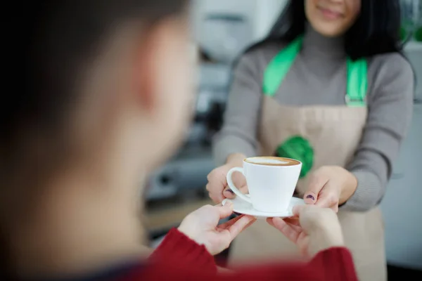 Barista in schort in coffeeshop geven alleen gebrouwen verse koffie naar klant — Stockfoto