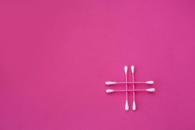 Pembe arka planda çapraz biçimli beyaz başlı dört pembe pamuk tomurcuğunun üst görüntüsü