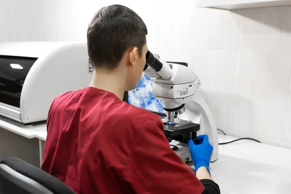 Jovem cientista olhando através de um microscópio em um laboratório. Yo. — Fotografia de Stock