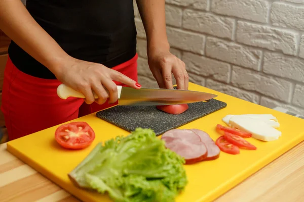 Tomate de fatia de mulher. Cozinhar a partir de legumes frescos — Fotografia de Stock