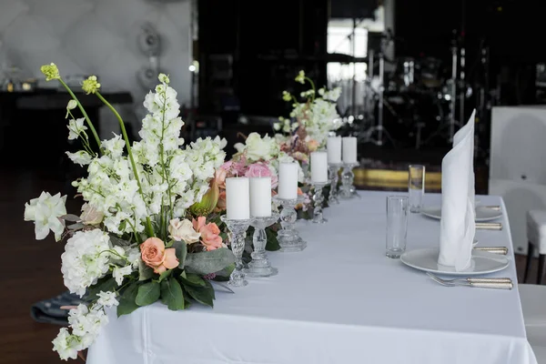 De tabel van de pasgetrouwden in restaurant decoratie verse bloemen en kaarsen. Bruiloft verse bloemen decoratie — Stockfoto