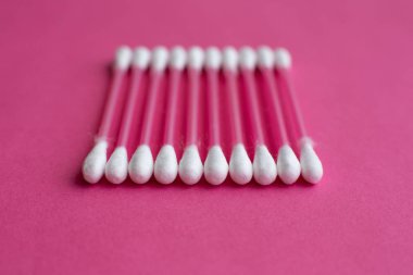 Pamuk tomurcuklarının yakın plan yan görüntüsü pembe arkaplan üzerinde yatay bir çizgide yatar