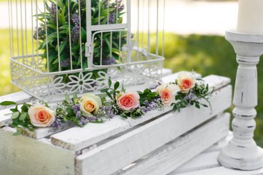 Festival rustik tarzı dekorasyon taze çiçekler ve bir ahşap kutu üzerinde beyaz kuş kafesi. Güneşli yaz gün