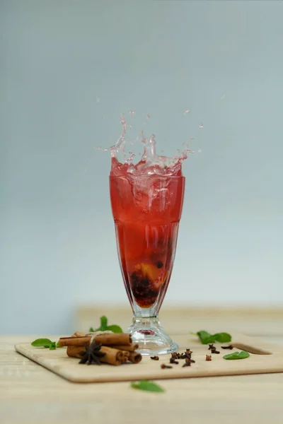 Splash Cup of hot vitamin tea on wooden table. winter hot season — Stock Photo, Image