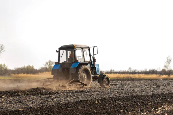 Un tracteur laboure un champ pour semer des cultures — Photo