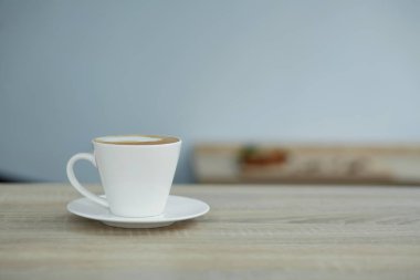 Tahta masada beyaz bir fincan kahve.