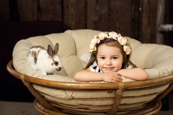 Çiçek çelenk, güzel küçük bir kız portresi. Şirin bir kabarık beyaz Paskalya tavşanı bir kızla — Stok fotoğraf