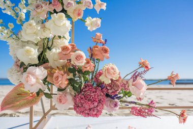 Taze çiçeklerle süslenmiş düğün kemer parçası üzerinde Nehri'nin kıyısında kumlu ayarlanır. Düğün çiçekçi iş akışını düzenler