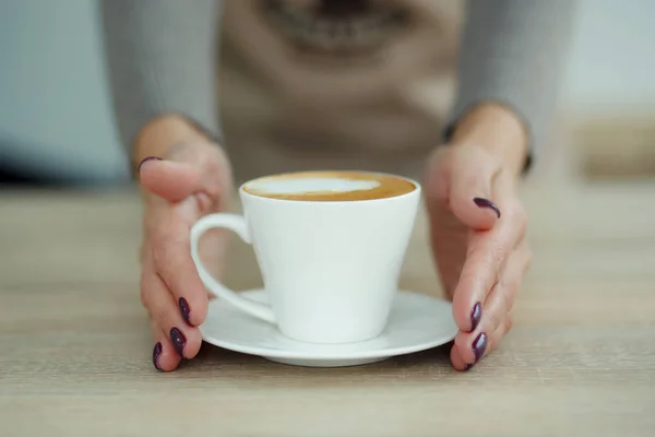 Бариста в фартуке в кафе дают только что сваренный свежий кофе — стоковое фото