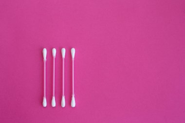 Beyaz kafaları ile dört pembe pamuk tomurcukları üzerinde üst görünüm pembe bir arka planda dikey çizgi dışarı koydu
