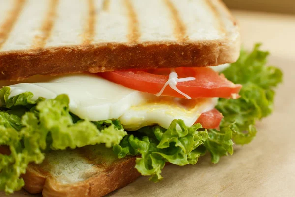 Крупним планом соковитий бутерброд з беконом, свіжі овочі, зелений салат — стокове фото