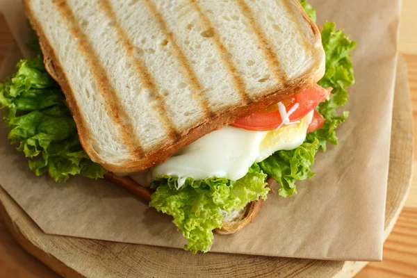 Closeup juicy sandwich with bacon, fresh vegetables, green salad — Stock Photo, Image