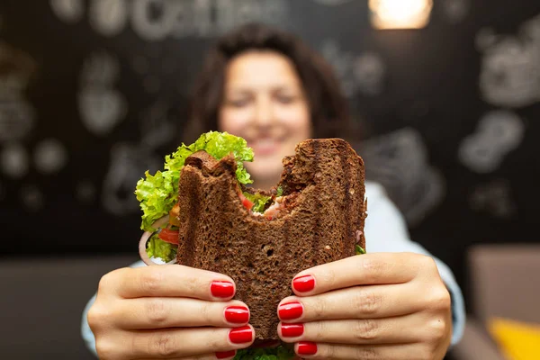 Closeup engraçado desfocado protrait de jovem mulher segurar mordido sandwi — Fotografia de Stock