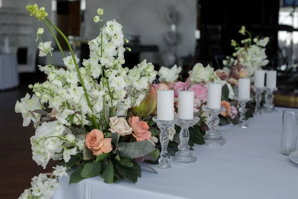 Столу молодят в прикрасі ресторану свіжі квіти та свічки. Прикраса весіль свіжими квітами — стокове фото