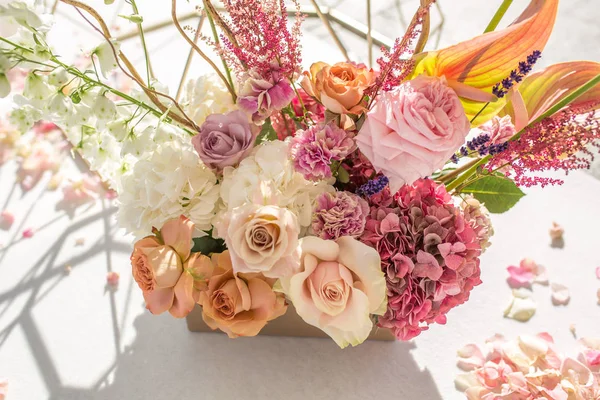 Onderdeel van de huwelijksboog gedecoreerd met verse bloemen ligt aan de zandige oevers van de rivier. Bruiloft bloemist regelt werkstroom — Stockfoto