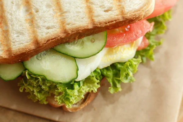 Closeup ζουμερά σάντουιτς με μπέικον, φρέσκα λαχανικά, πράσινη σαλάτα και σκούρες γραμμές μετά Γκριλ — Φωτογραφία Αρχείου