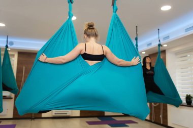 Kadının sinek yoga esneme yapması hamakta uygular. Uyum ve biz