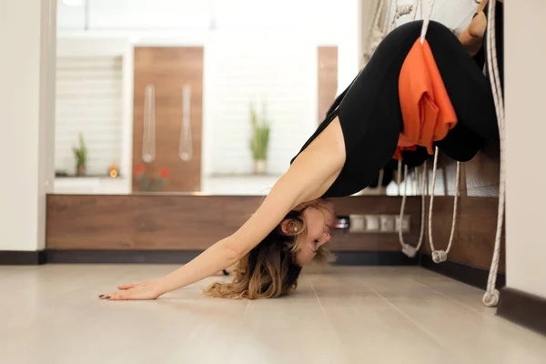 Donna che pratica yoga su corde che si estende in palestra. Stile di vita adatto e benessere — Foto Stock