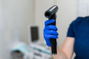 Doktor eli mavi kauçuk eldiven içinde. Profesyonel göz doktoru aletini tut.