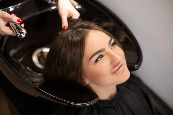 Haircut master washes hair of her client\'s had
