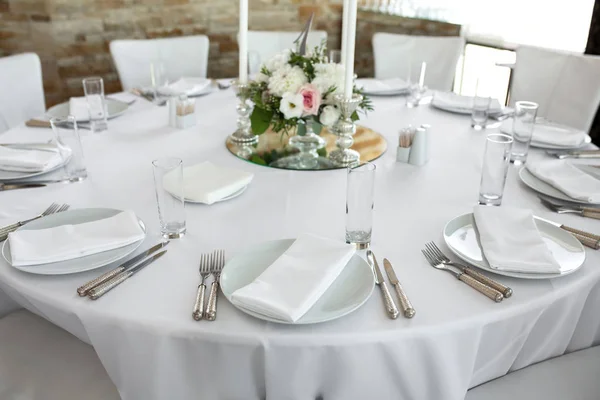 Обстановка весільного столу прикрашена живими квітами. Білі тарілки — стокове фото