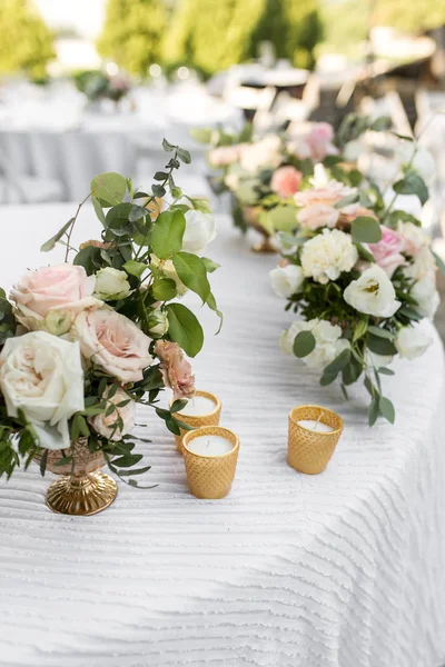 Mesa de boda decorada con flores frescas en una va de latón — Foto de Stock