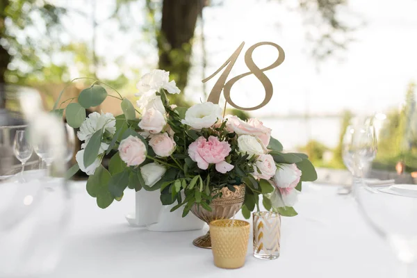 Mesa de boda decorada con flores frescas en una va de latón — Foto de Stock