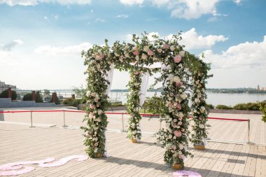 Açık hava düğün töreni için taze çiçeklerle süslenmiş neşeli bir chuppah.