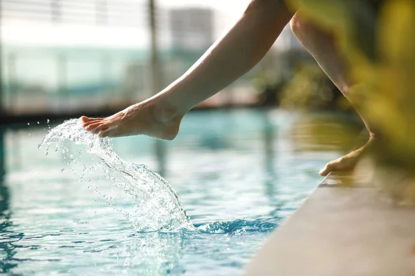 Vértes fiatal nő lábát, hogy kék vizet úszás p — Stock Fotó
