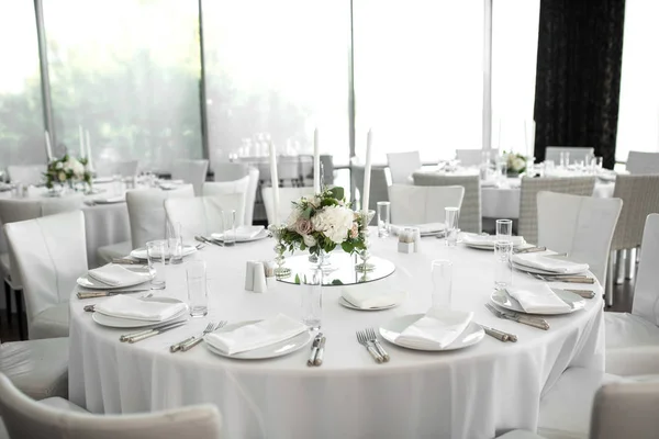 Bruiloft tafel decoratie versierd met verse bloemen. Witte borden, zilverwerk, wit tafelkleed en witte kamer. Bruiloft bloemisten. Bankettafel voor gasten. Boeket met rozen, hortensia en eustoma — Stockfoto