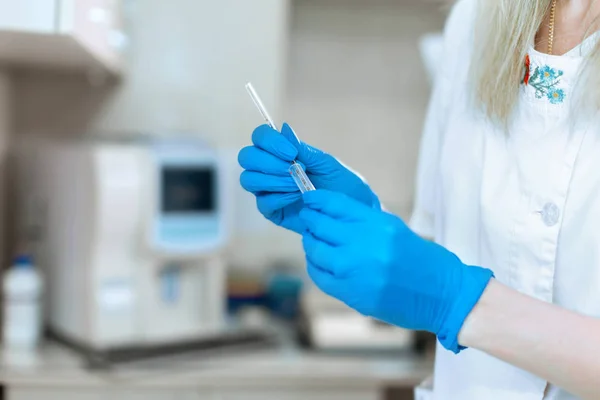 女性のブロンドのラボ技術者は、青いglと血液サンプルを取ります — ストック写真