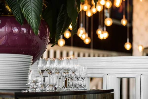 Clean empty glasses stand on the table next to a stack of white — Stock Photo, Image