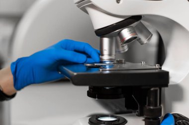 adam mavi eldiven araştırma içine malzeme ile cam yükleme