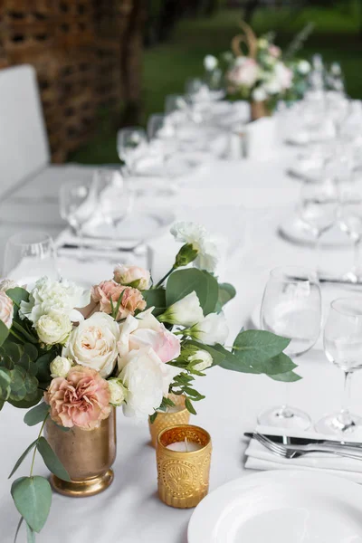 Cenário de mesa de casamento decorado com flores frescas em uma va de latão — Fotografia de Stock