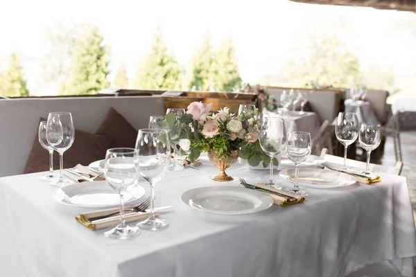 Mesa de boda decorada con flores frescas en una va de latón — Foto de Stock