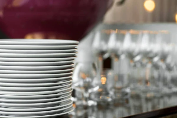 Una pila de platos blancos limpios está sobre una mesa con una pestaña blanca — Foto de Stock