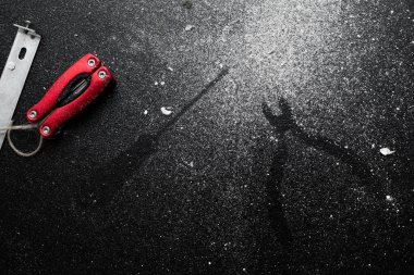 Lambanın kendi kendine kurulumu için bir takım araç gereç siyah bir masanın üzerinde, beyaz tozla serpilmiştir. Bir saatliğine kocayım. Ev işleri.