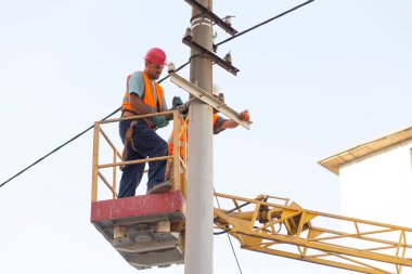 Sütunlardaki elektrikçiler elektrik hattına monte ediyorlar. Profesyonel elektrikçiler kulede çalışıyor. Dnipro / Ukrayna - 08.10.2019