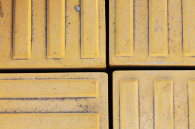 Görme engelli insanlar için çıkıntıları olan yapısal açık fayanslar. Körler için döşeme yolu tabelası.