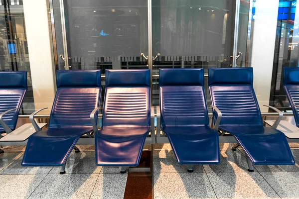 Comfortable seats with foot rest in the waiting area at the airport.